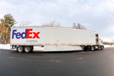 Whitesboro, New York - 19 Ocak 2026: 1971 'de kurulan bir ABD lojistik sağlayıcısı olan FedEx Express, karlı bir yol kenarında park halinde markalı yarı römork ile balık bakışı görüntüsünde gösterilmiştir.
