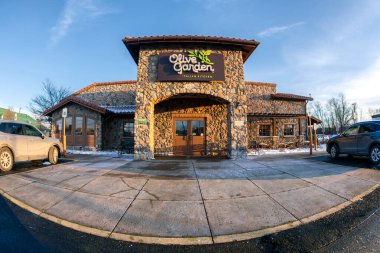 New Hartford, New York - 16 Ocak 2026: Olive Garden, 1982 'de kurulan günlük yemek zinciri, balık gözü manzaralı kış koşullarında markalı tabela ve taş cephe ile gösterildi