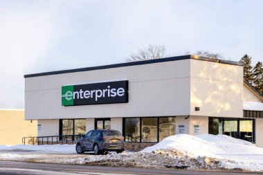 New Hartford, New York - 1 Şubat 2026: Bir kış reklamı ortamında karla kaplı bir araba kiralama mağazasının gündüz manzarası. Enterprise Rent-A-Car, ABD 'nin en büyük kiralık markasıdır.