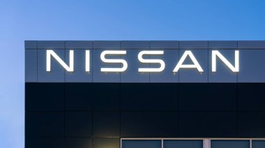 Yorkville, New York - 1 Şubat 2026: Ticari bir otomotiv ortamında alacakaranlık gökyüzüne karşı modern bir karanlık cephede gösterilen aydınlanmış NISSAN dış tabelaları