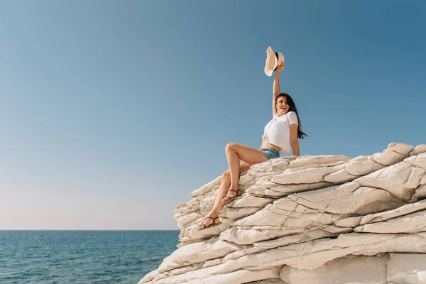 Hermosa chica en pantalones cortos y un sombrero junto al mar en Chipre — Foto de Stock