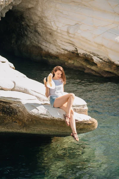 Hermosa chica en pantalones cortos y un sombrero junto al mar en Chipre — Foto de Stock