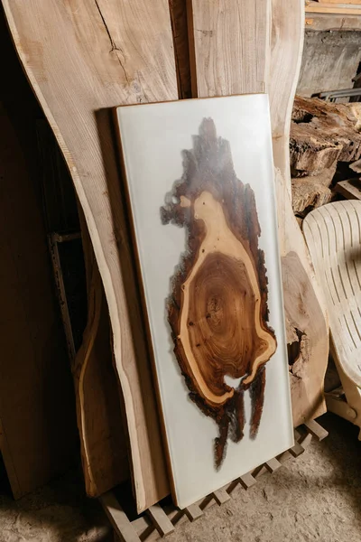 Exclusiva mesa artesanal de madera maciza y resina epoxi sobre fondo de  tableros de madera