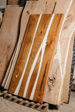 Ahşap arka planda sağlam ahşap ve epoksi reçineden yapılmış özel el yapımı bir masa.