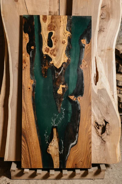 Mesa exclusiva hecha a mano de madera maciza y resina epoxi sobre el fondo de tableros de madera — Foto de Stock