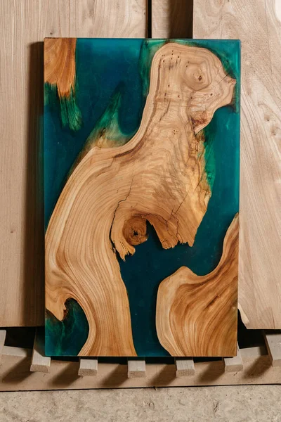 Mesa exclusiva hecha a mano de madera maciza y resina epoxi sobre el fondo de tableros de madera — Foto de Stock