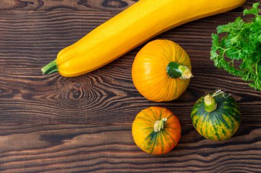 Kahverengi ahşap arka planda balkabağı, kabak ve maydanozlu şükran günü için sonbahar durgun. Boşluğu kopyala