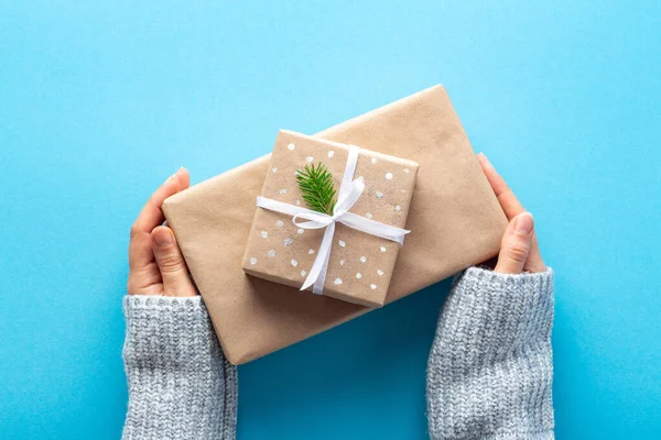 Vrouw Handen Houden Nieuwjaar Geschenken Eco Inpakpapier Blauwe Achtergrond — Stockfoto