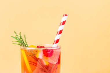 Limon, ahududu ve bej kaplama biberiyeli alkolsüz kokteyl. Limonata ve çizgili tek kullanımlık pipetle yaz sıcağı için..