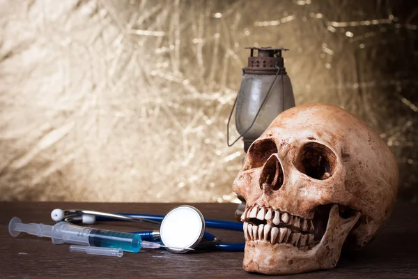 Weathered human skull and syringe — Stock Photo, Image