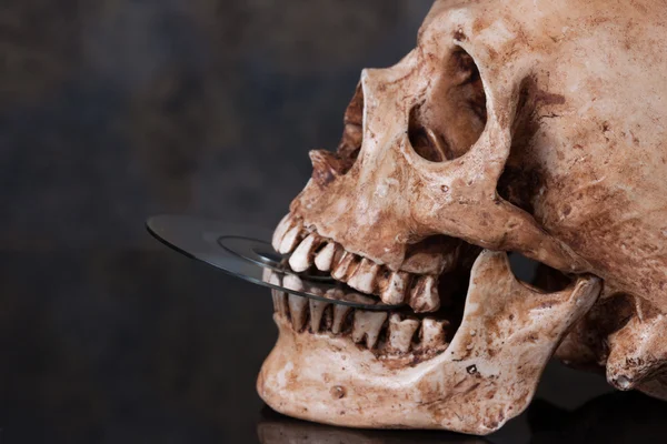 Crânio humano e dvd na boca — Fotografia de Stock