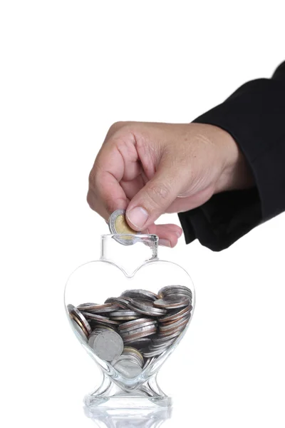 Hand putting a coin into glass — Stock Photo, Image