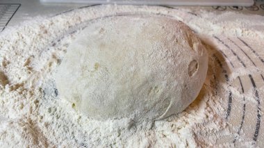 Mutfaktaki masada ekmek ve un var.