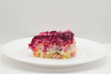 Beyaz tabakta kürk manto salatası altında ringa balığı