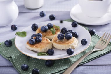 Süzme peynirli krep, beyaz tabakta şerbet ve taze yaban mersini. Sağlıklı ve lezzetli bir sabah kahvaltısı. Süper manzara, fotokopi alanı..