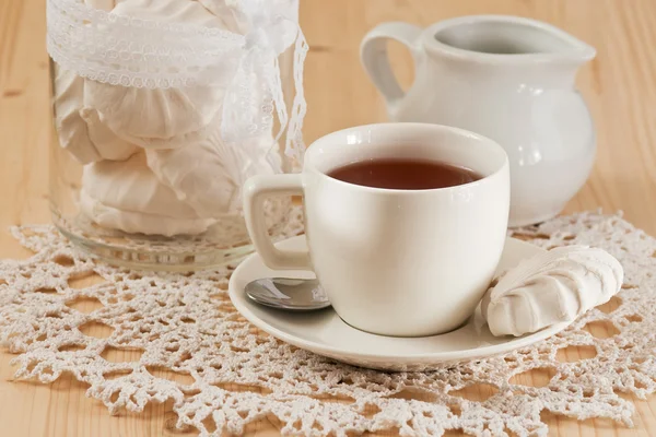 Чашка чая с корицей и зефиром на кружевной салфетке — стоковое фото