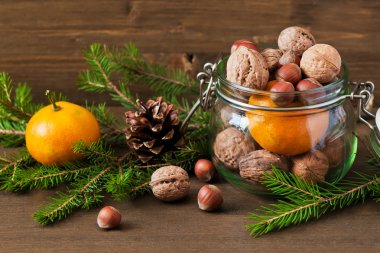 Noel kavramı (dekorasyon). Mandalina, koni ve ceviz rustik ahşap zemin üzerine kavanoz