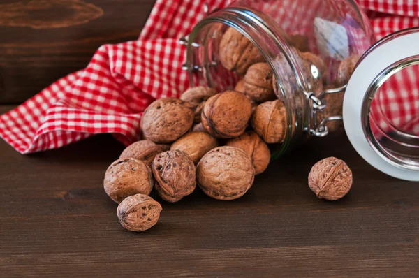 Valnötter i tabellen trä med röd servett — Stockfoto