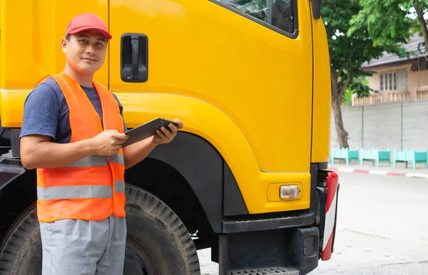 Asian truck driver in safety clothes smile confident. Happy owner transportation business stand proudly hug his chest. Driving trainer Skills in school, teaching, safety, driving license.
