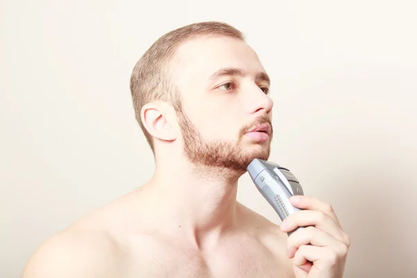 ひげを生やした男のひげをそる電気かみそり — ストック写真