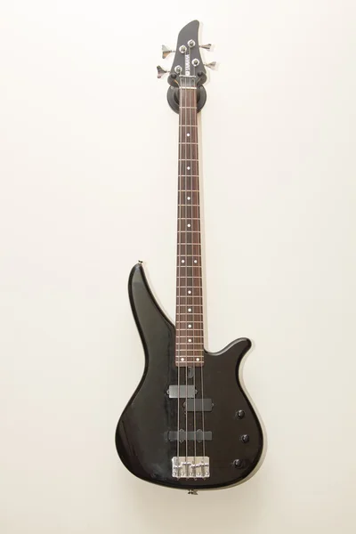 Basso nero chitarra elettrica appesa al muro — Foto Stock