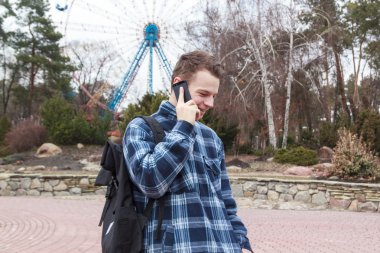adam telefonda konuşurken bir sırt çantası ile