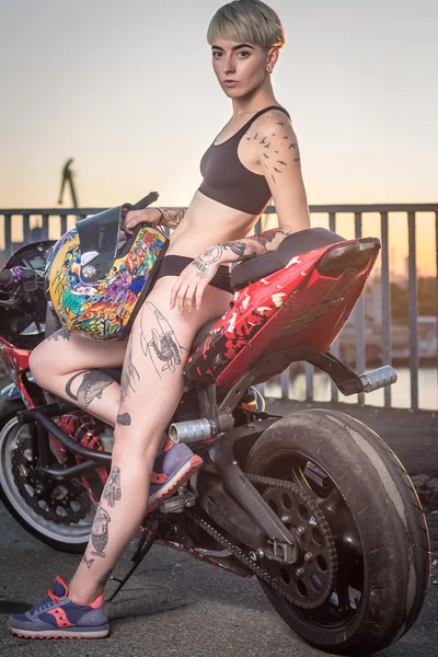 Fille avec des tatouages assis sur une moto — Photo
