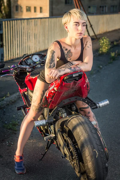 Menina com tatuagens sentado em uma motocicleta — Fotografia de Stock