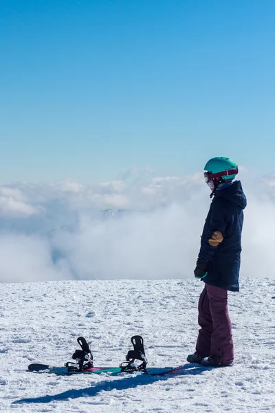 Flicka i bergen med en snowboard — Stockfoto