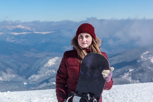 Meisje in de bergen met een snowboard — Stockfoto