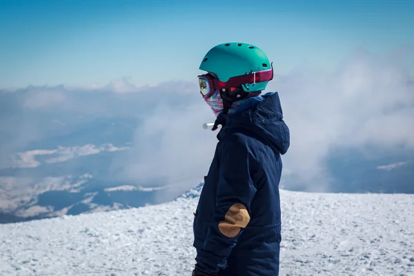 雪をかぶった山の背景にヘルメットの少女 — ストック写真