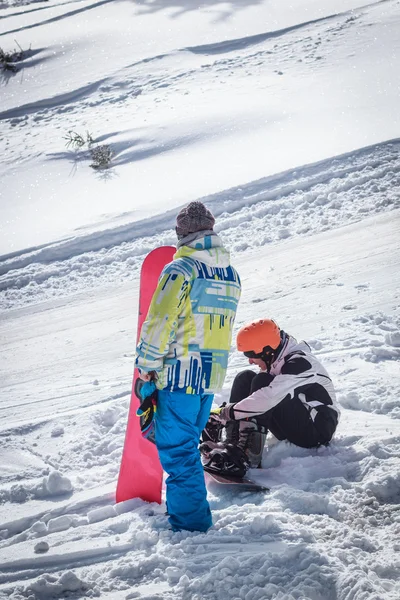 Killen i de snöklädda bergen med en snowboard — Stockfoto