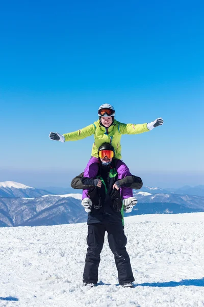 Meisje en jongen op de met sneeuw bedekte bergen — Stockfoto