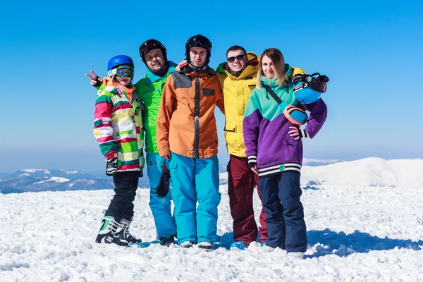 Vrolijke jongeren op een besneeuwde berg — Stockfoto