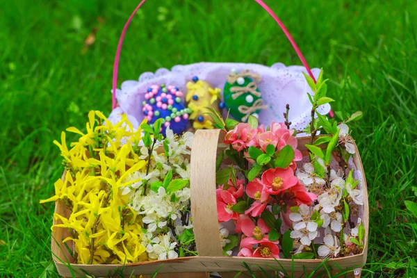 Korb mit Blumen und ein Korb mit Ostereiern — Stockfoto