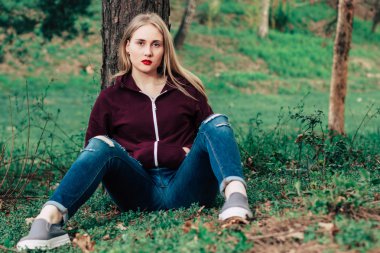 çimenlerin üzerinde oturan güzel kız modeli 