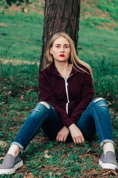 Çimenlerin üzerinde oturan güzel kız modeli — Stok fotoğraf