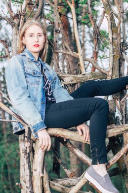 Moda sarışın yırtık kot oturuyor