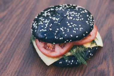 ahşap bir tahtada siyah burger