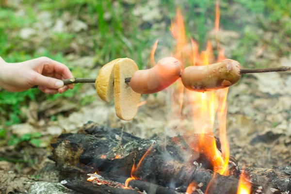 Salchicha en un pincho asado en el fuego — Foto de Stock