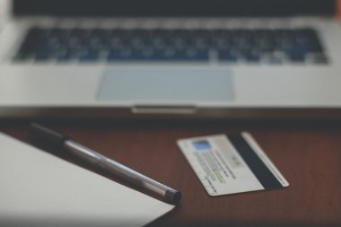 laptop, banka kartı ve defter