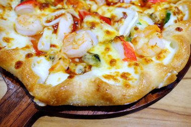 Tahta tabakta deniz ürünleri pizzası.