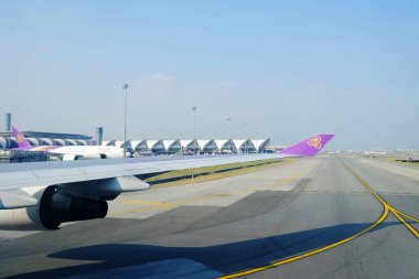 BANGKOK, THAILAND - 17 Kasım 2019: Suvarnabhumi havaalanı Tayland arka planlı Tayland Havayolları kanadı. Tayland Havayolları Mart 1960 'da kuruldu..