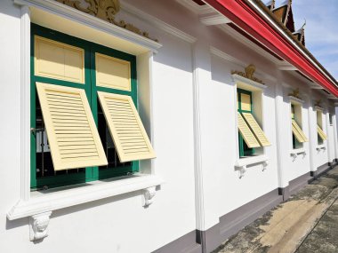 Yeşil Pencere Çerçeveleri ve Sarı Panjurlu Geleneksel Tayland Mimarisi.