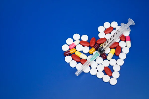 Syringe op geneeskunde gerangschikt als een hart vorm — Stockfoto