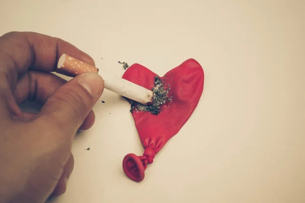 Cigarette burnt a red heart — Stock Photo, Image