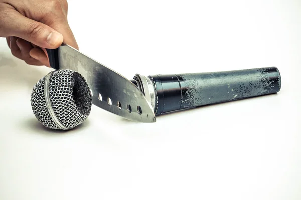Mano che tiene un coltello che taglia un microfono — Foto Stock