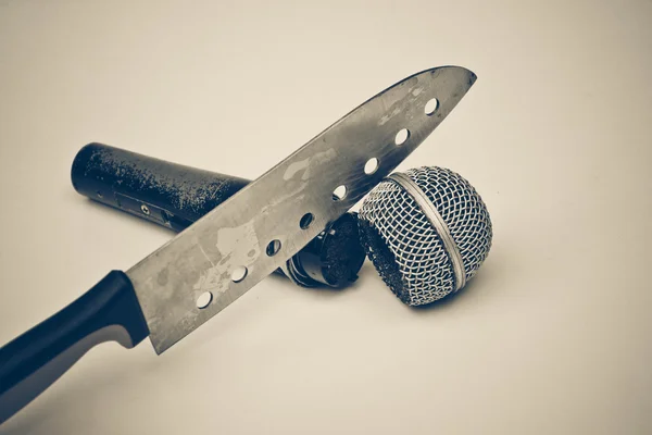Mão segurando uma faca cortando um microfone — Fotografia de Stock