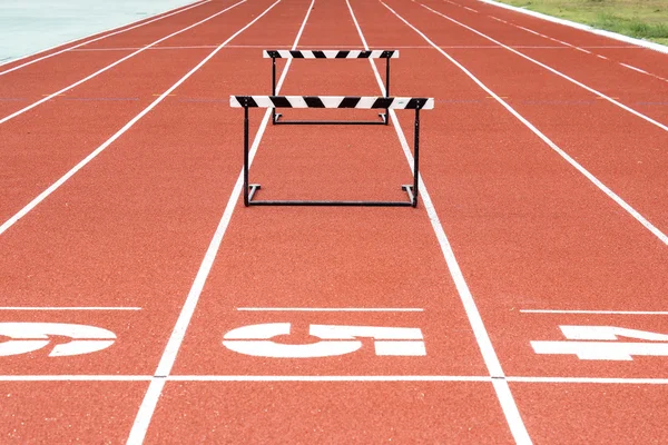 Springen horden op de atletiekbaan — Stockfoto