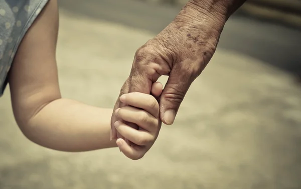 Hand eines jungen Babys berührt alte Hand — Stockfoto